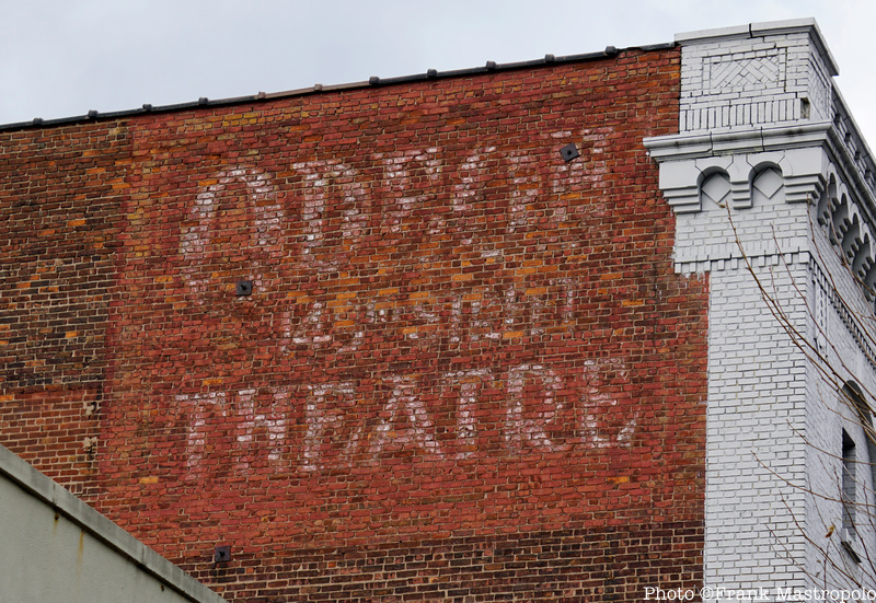 Odeon Theater ghost sign painted at the top of a brick wall on a building in NYC