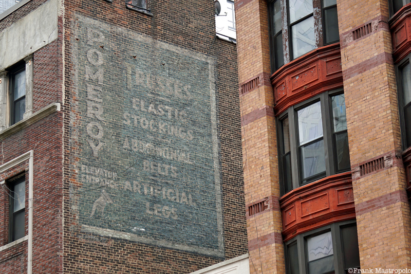 A fading Brooklyn ghost sign on the side of a brick building