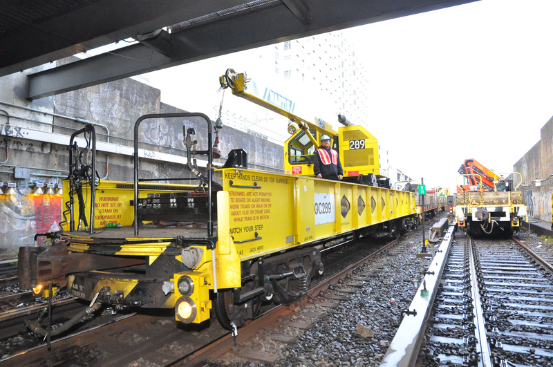 A yellow crane car on subway tracks