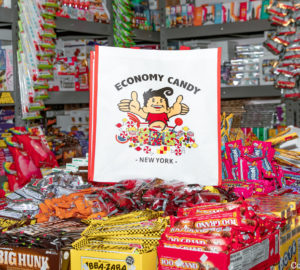 A bag with the Economy Candy logo sits on top of a pile of colorful candies