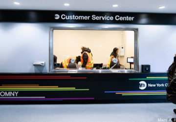 Two workers stand inside a new MTA Customer Service Center at the Coney Island subway station