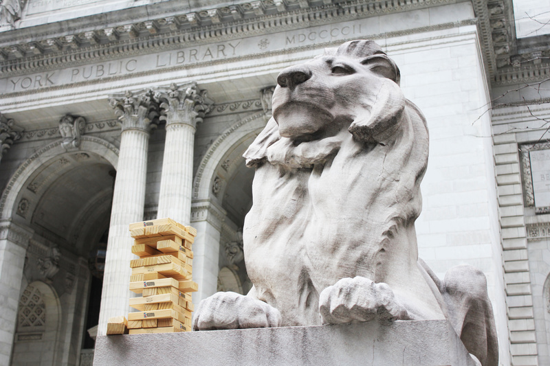 A stack of JENGA blocks next to one of the lion sculptures at NYPL
