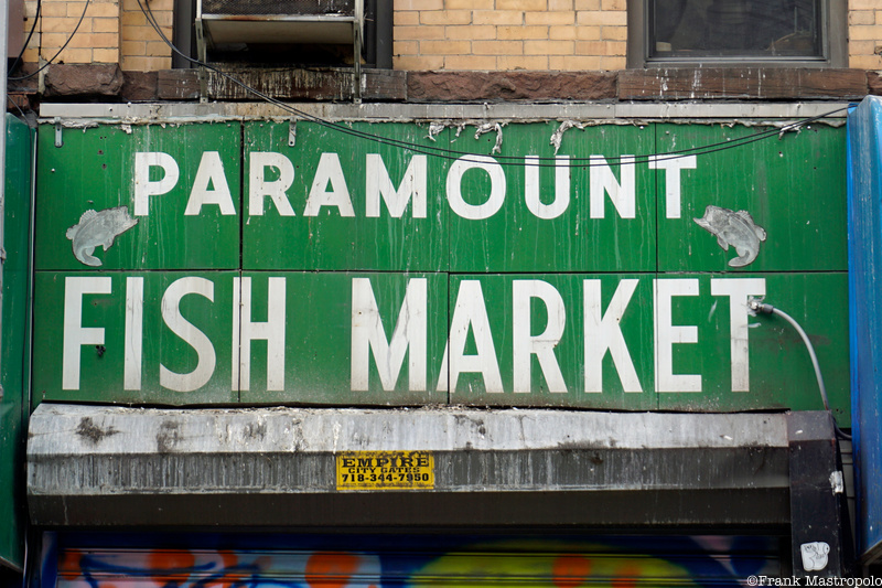 A green sign with white letters that reads "Paramount Fish Market"