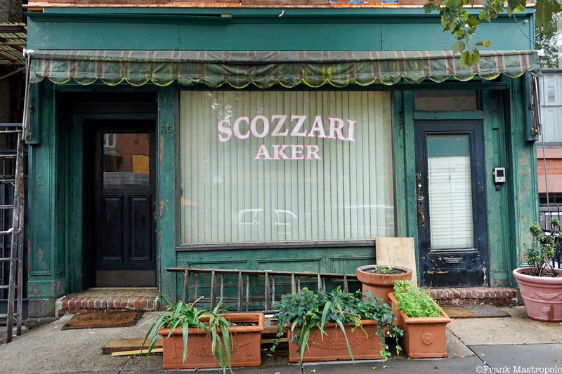 A Brooklyn storefront with a green awning and a large window that reads "Scozzari Bakery"