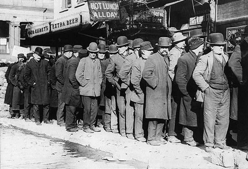 A photograph from 1910 shows men standing in a bread line on the Bowery.