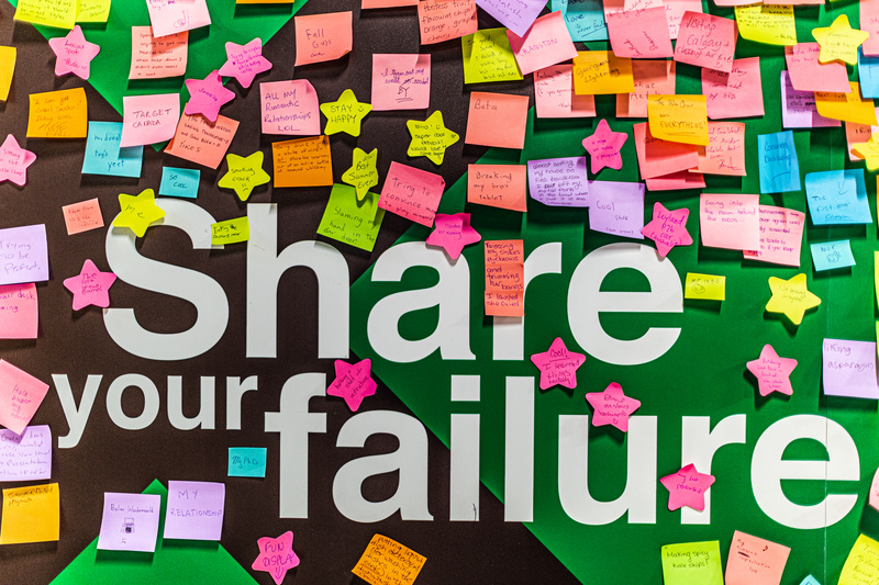 Colorful post-it notes on a wall that says "Share Your Failure" at the Museum of Failure
