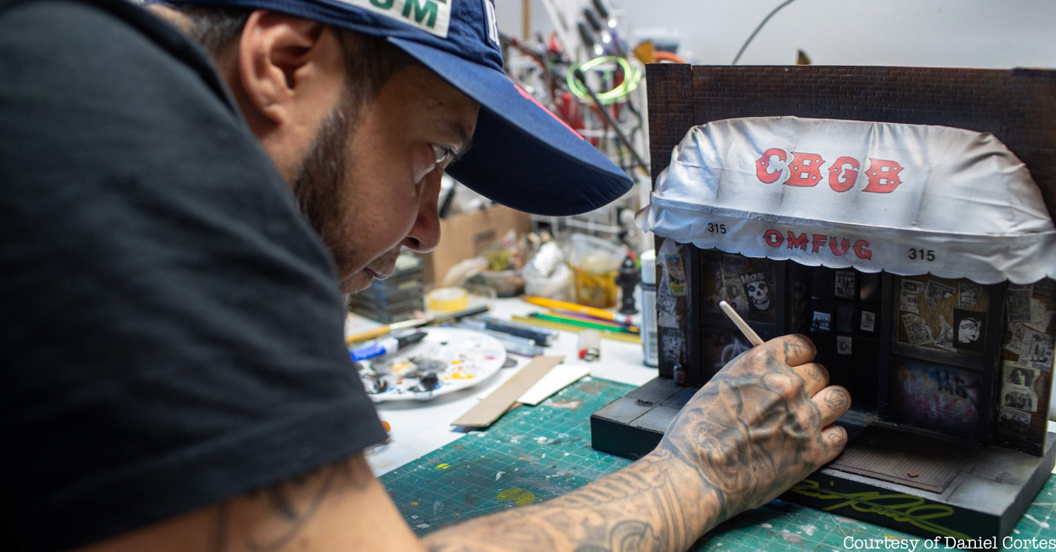 Daniel Cortes painting a miniature version of CBGB