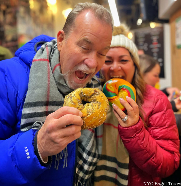 A man and woman eating bagels