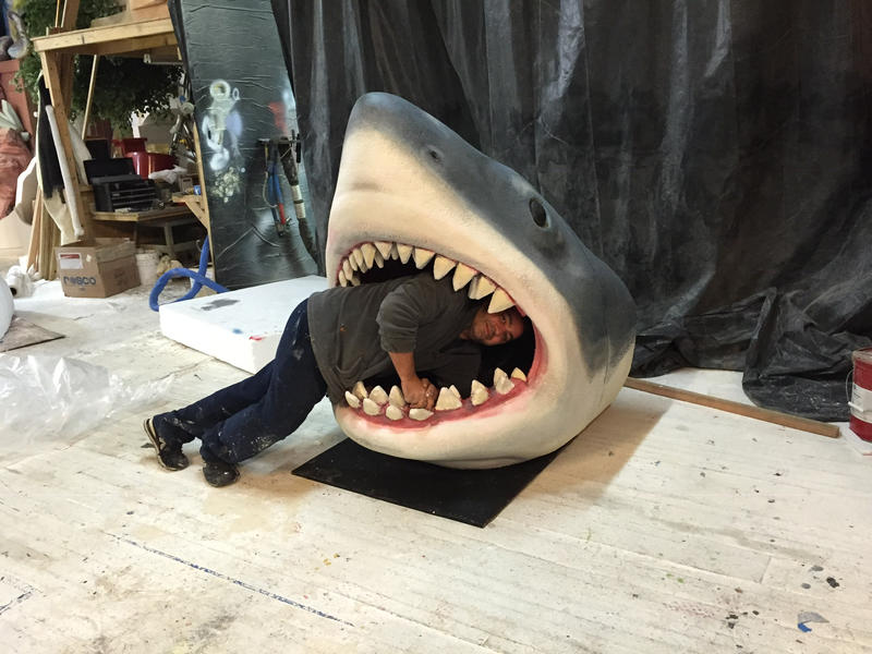 Joseph Reginella posing inside the mouth of a shark sculpture