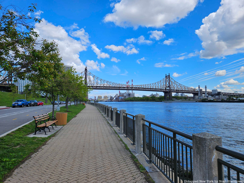 A Walking path along the East River with a view of the Queensboro Bridge