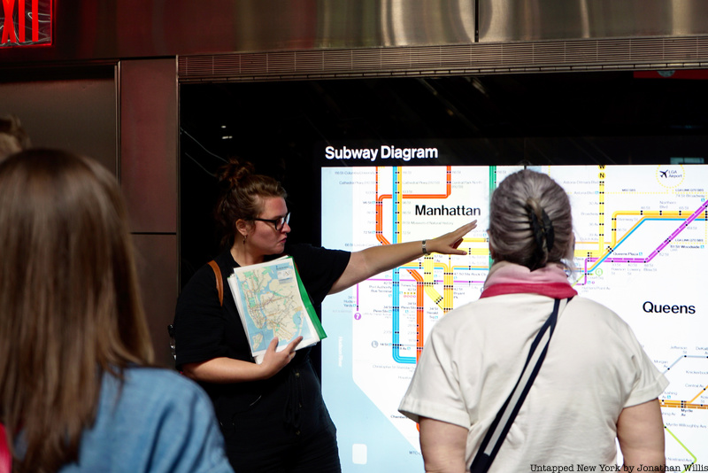 A tour guide points to a subway map