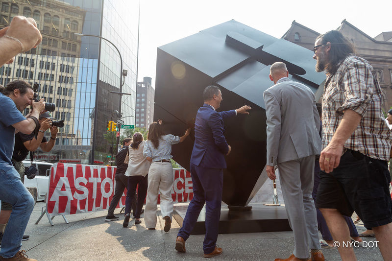 Astor Place Cube being spun by a group of officials