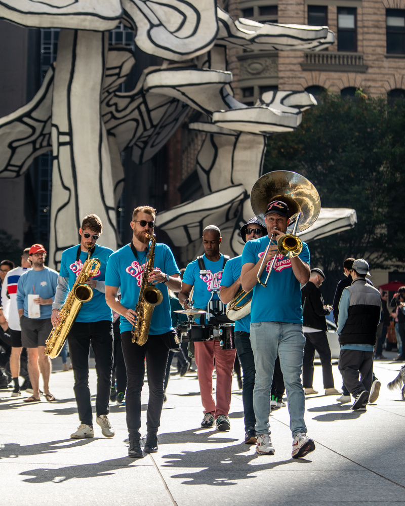 A band plays at Fosun Plaza in front of vintage cars in NYC