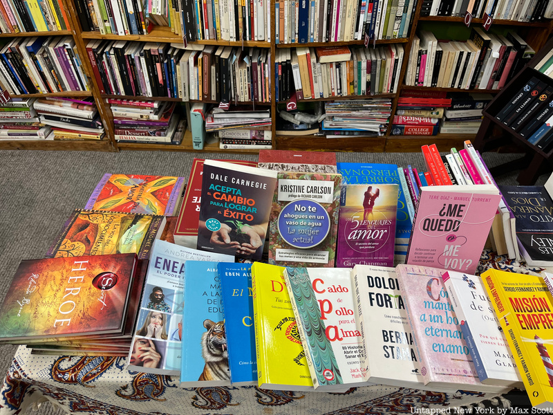 A table filled with books at Librería Barco de Papel bookstore in Queens
