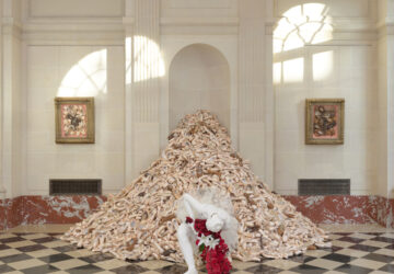 Pile of pointe shoes with ballerina in front