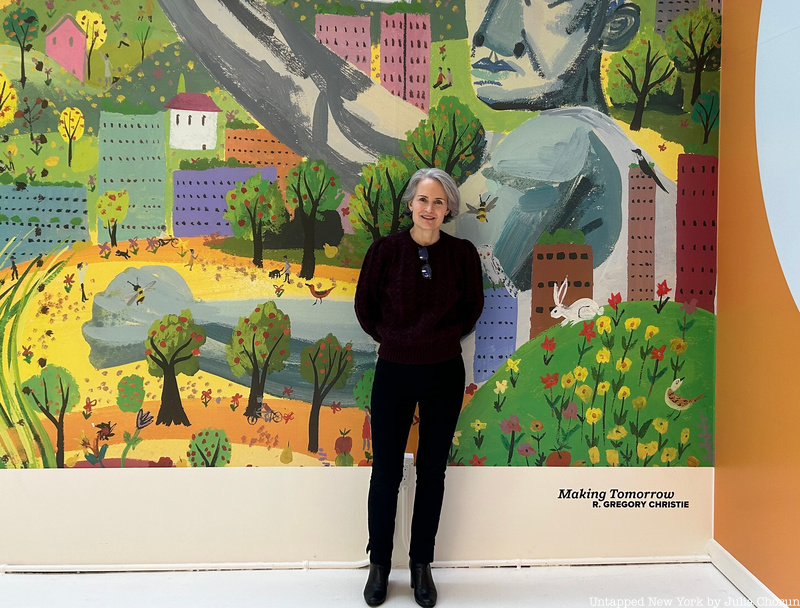 Miranda Massie stands in front of a colorful mural