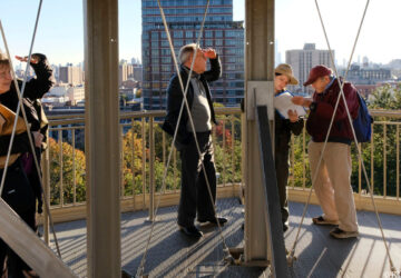 A group of Insiders look out at the view from the top of the Harlem Fire Watchtower