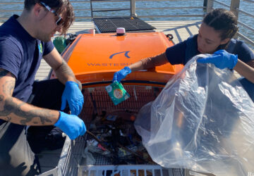 Two volunteers remove waste from the WasteShark