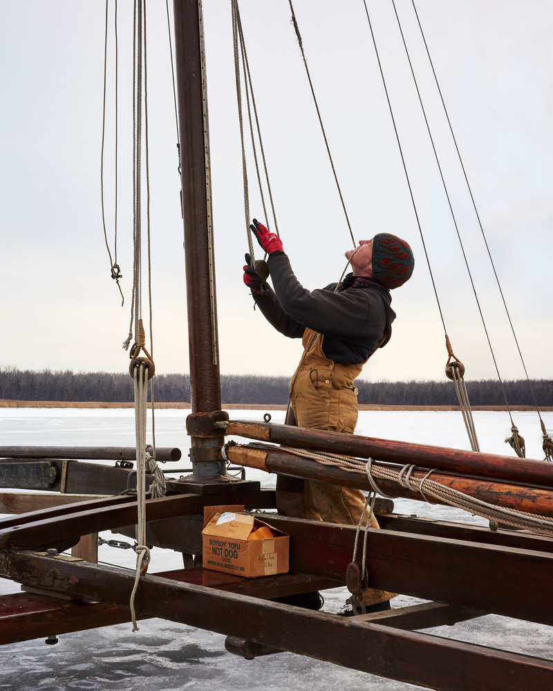 Man hoisting sail on an ice yacht