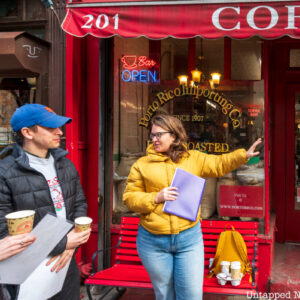 A group of people on a tour outside a coffee shop