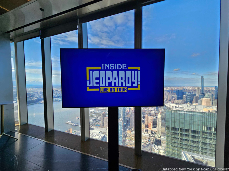 Jeopardy Live graphic on a television screen with the NYC skyline in the backgroun