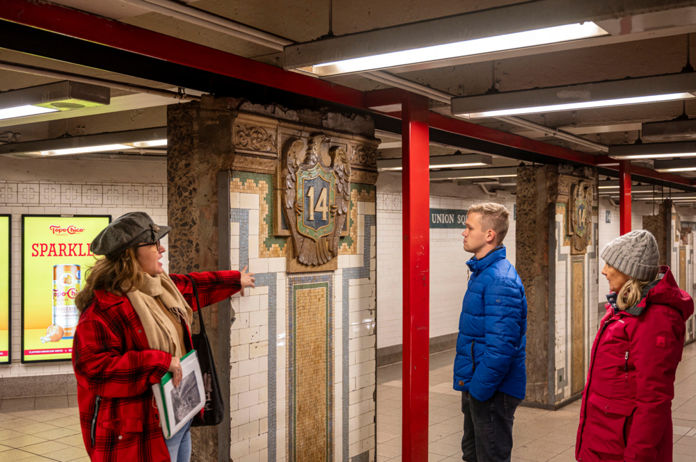 Guests on a subway tour looking at a piece of art