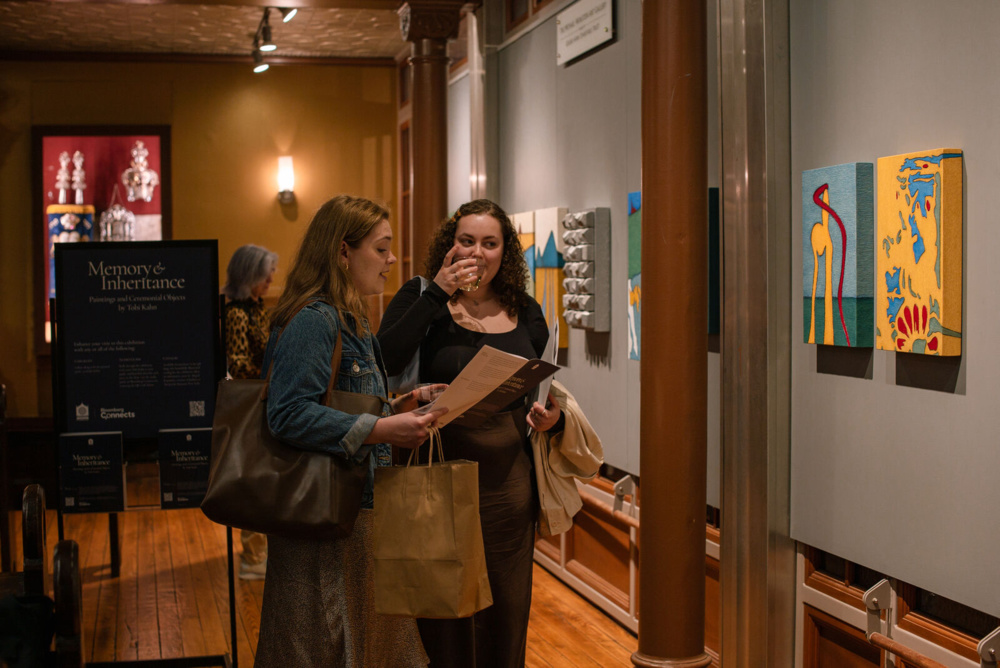 Two people admire art by Tobi Kahn at the Museum at Eldridge Street